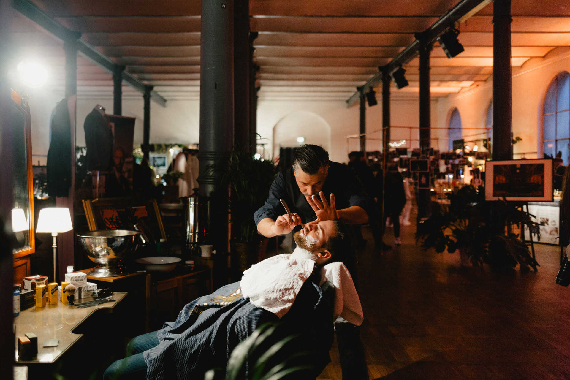 Barbiersetting mit einem Mann, der eine Rasur bekommt, auf einem Event.