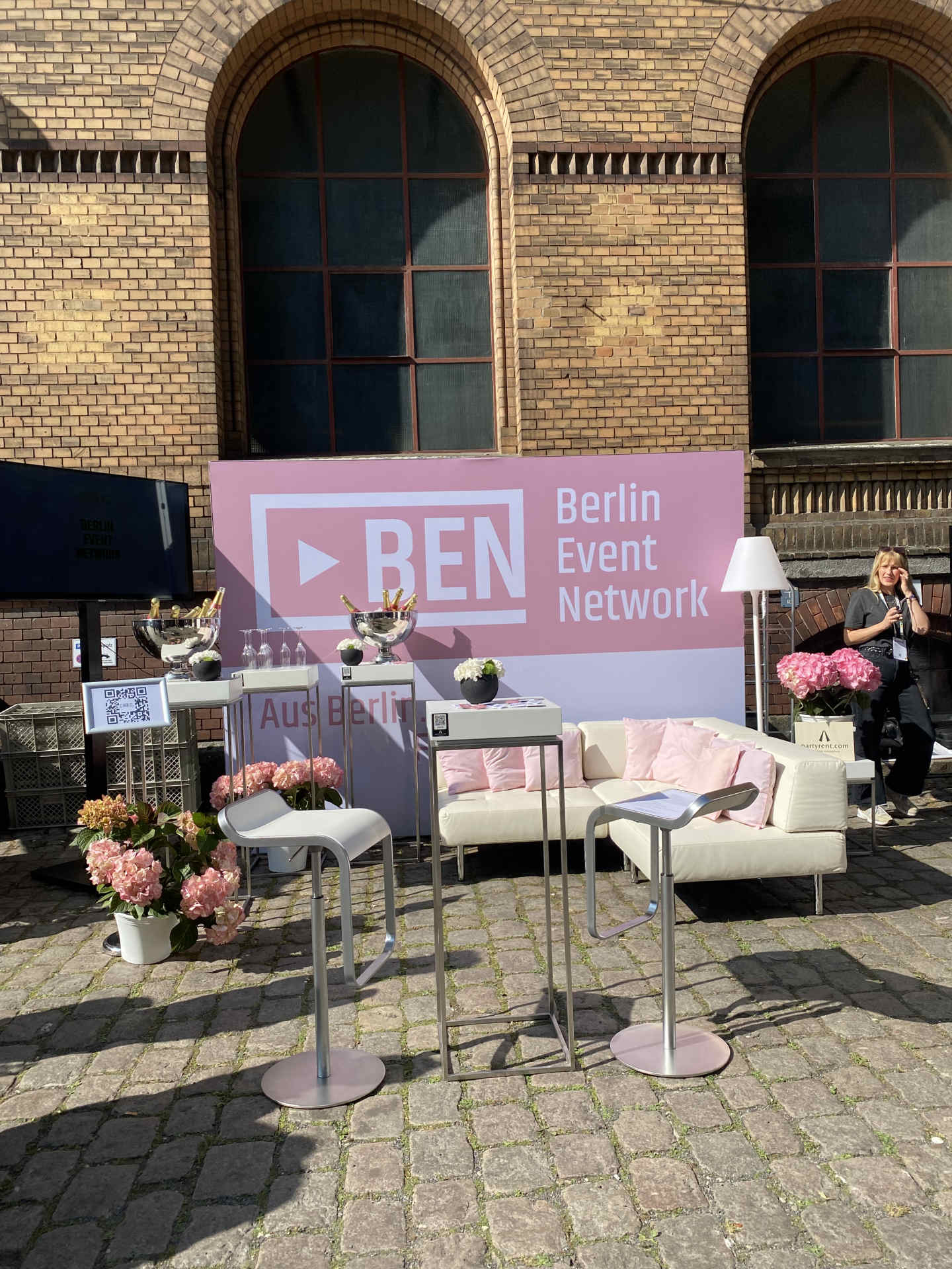 Event Außenbereich Station mit Loungebereich mit weißen Sitzmöbeln und rosa Deko