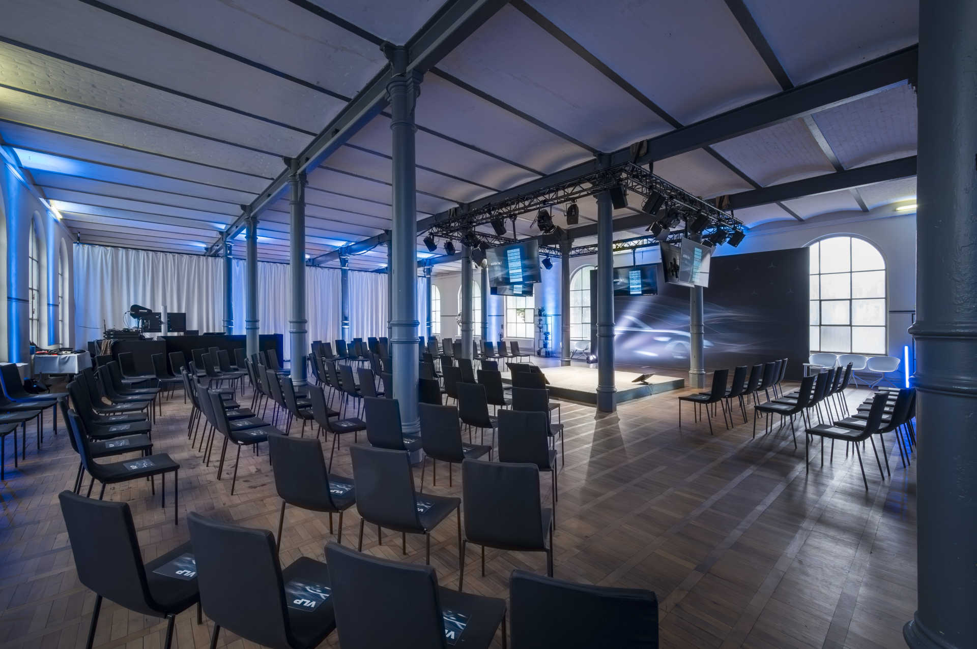 Großer Saal mit zentraler Bühne und Konferenzbestuhlung