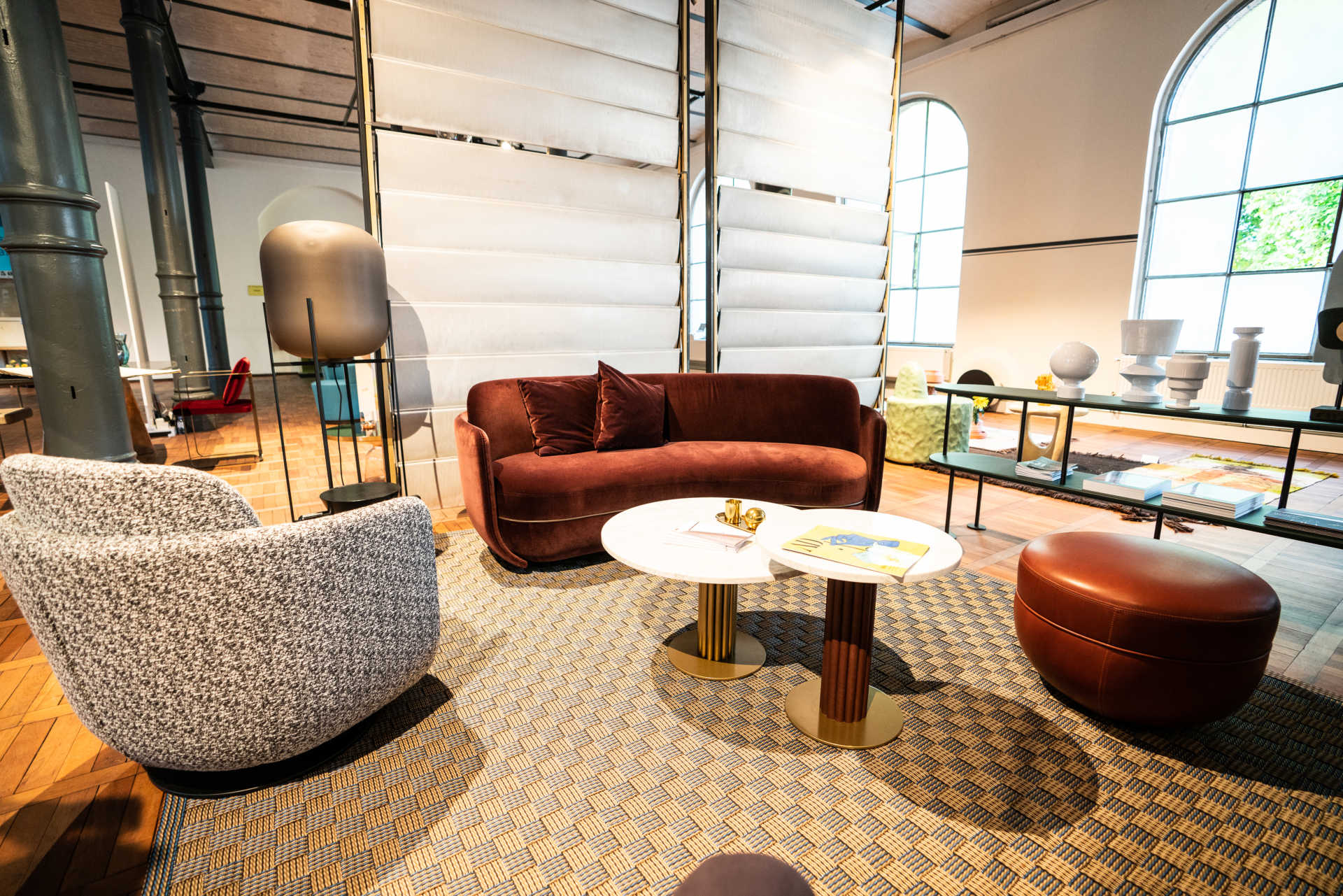 Ausschnitt einer Möbelmesse mit Designer Sesseln und Jalousie Raumtrenner.