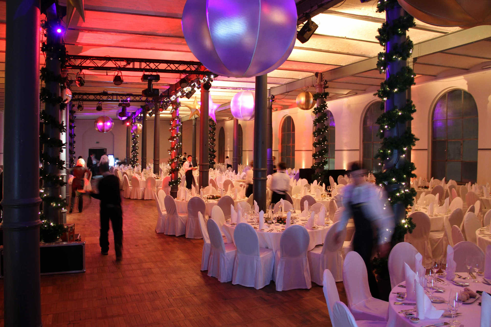 Festsaal mit runden Dinnertischen und Weihnachtsdekoration