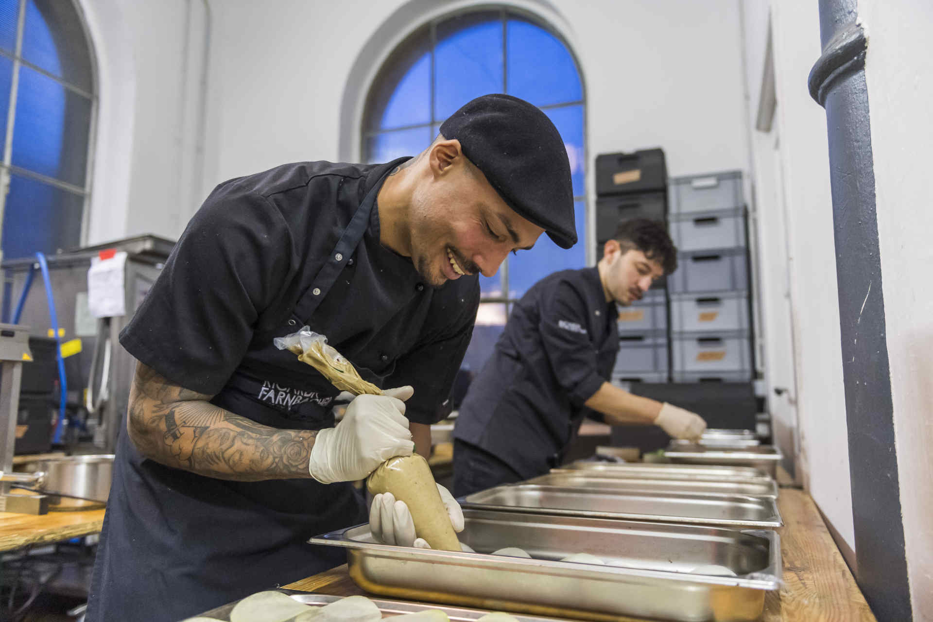 Momentaufnahme in einer Küche, wo von 2 Köchen Essen vorbereitet wird