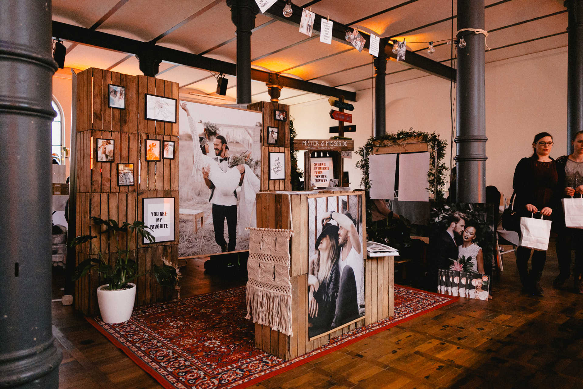 Ausstellungsfläche einer Hochzeitsmesse mit Perserteppich und Holzkisten im Boho Stil.